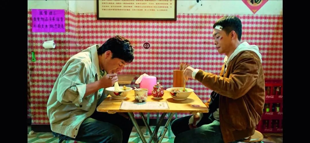 ·高启强(左,张颂文饰)和安欣(张译饰)坐在一起吃面。(视频截图)