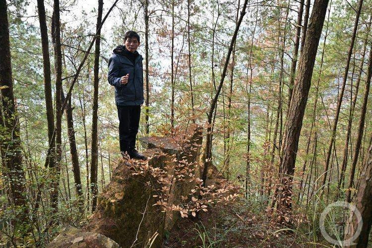 △从小在山上长大的刘智勇,站在“麻风村”仅剩的一截围墙上讲述过往