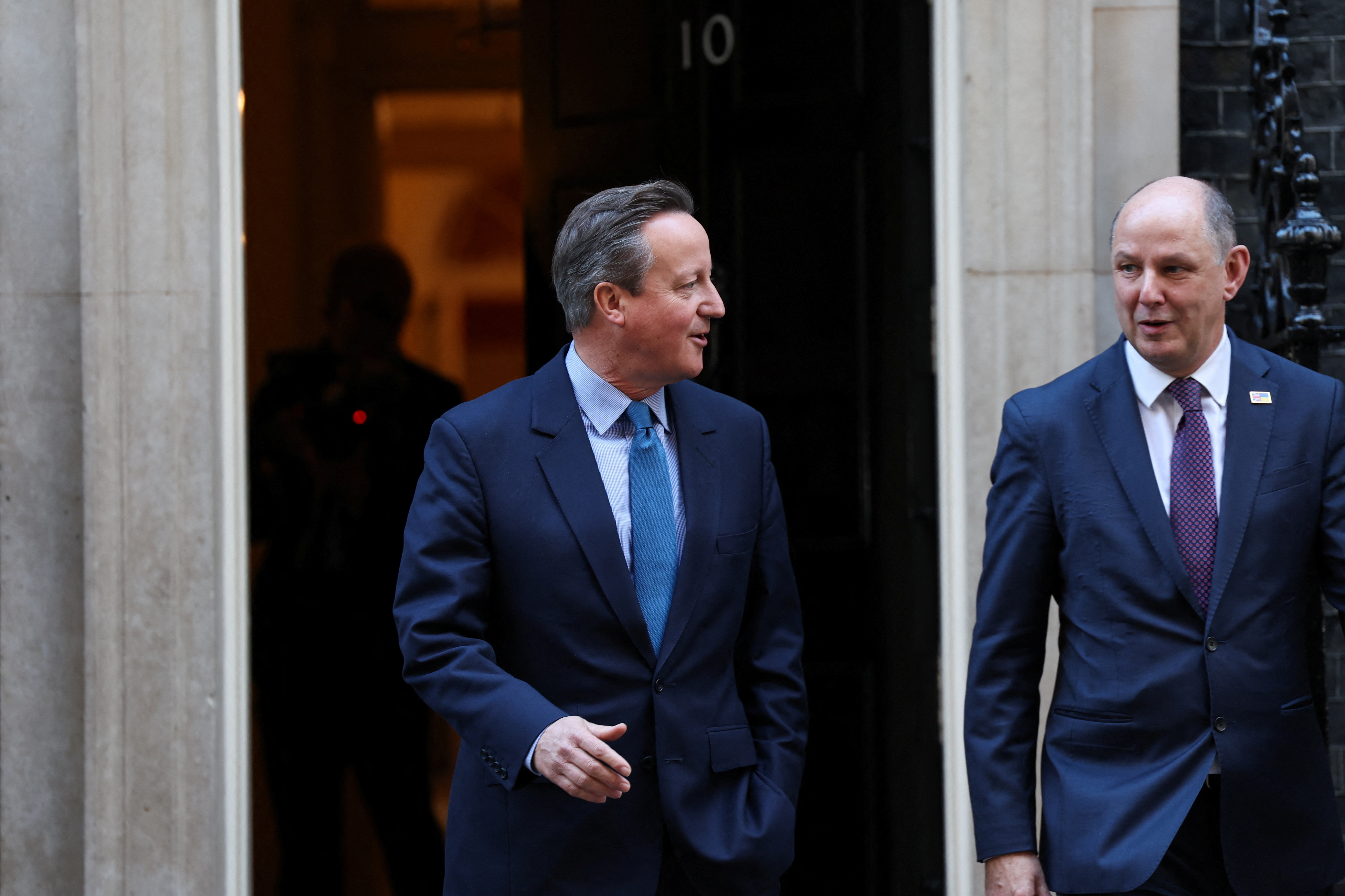 11月13日，在英国伦敦，新任外交大臣戴维·卡梅伦（左）走出唐宁街10号首相府。（路透社）