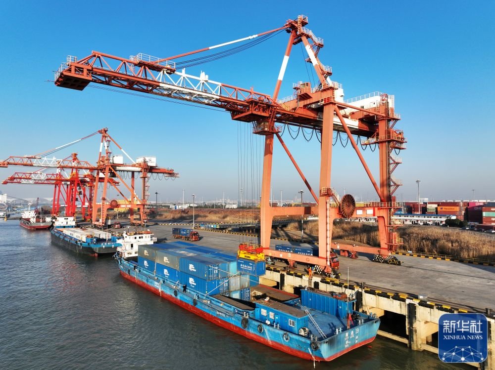 1月28日，货轮在江苏省扬州港集装箱码头进行集装箱装卸作业（无人机照片）。新华社发（孟德龙 摄）