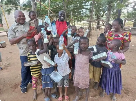 2022年6月，项目村儿童向中国农业大学团队塔桑尼亚协调人慕康果先生（Ernest Mkongo）展示对豆浆的喜爱。 图|中国农业大学官方公众号