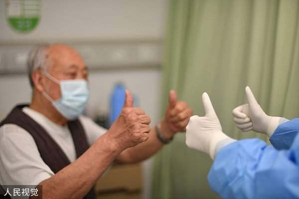 2020年4月26日,武汉市肺科医院77岁的新冠肺炎患者丁某第二次核酸检测结果为阴性,临床症状解除,达到出院标准。至此,武汉市所有新冠肺炎在院患者清零。最后一位患者丁爹爹和医生互致祝福。图源:视觉中国