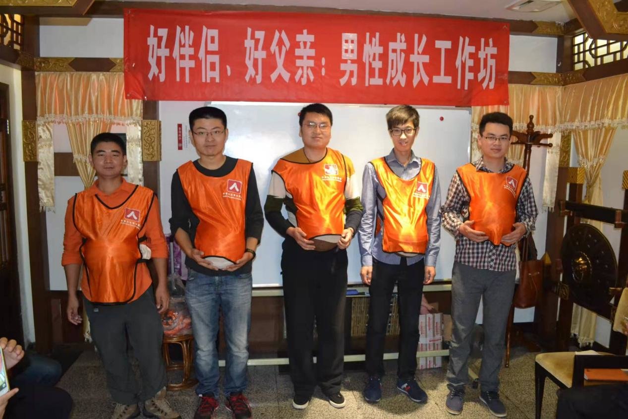 顾伟(左一)在2015年男德班上与其他学员合影,模拟女性怀孕的体验。 本文图片除特殊标注外,均为 受访者供图