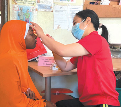 8月27日，中国（江苏）第三十二期援桑给巴尔医疗队眼科医生董莉莉（右）在坦桑尼亚桑给巴尔岛为当地患者检查。本报记者 侯露露摄