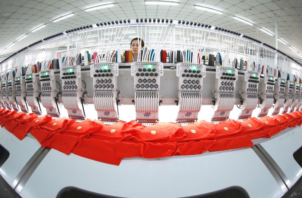 ▲3月14日,在山东青岛,工人在生产出口服装绣花产品。