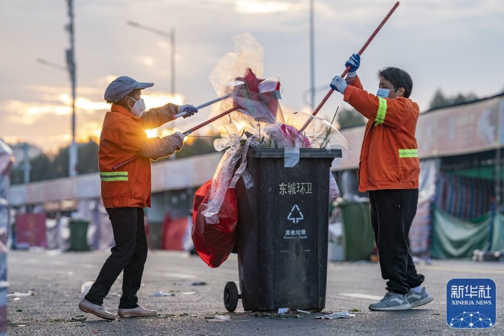 1月21日清晨,广东省清远市的环卫工人在进行道路保洁、垃圾清运工作。新华社发(邱炜民摄)