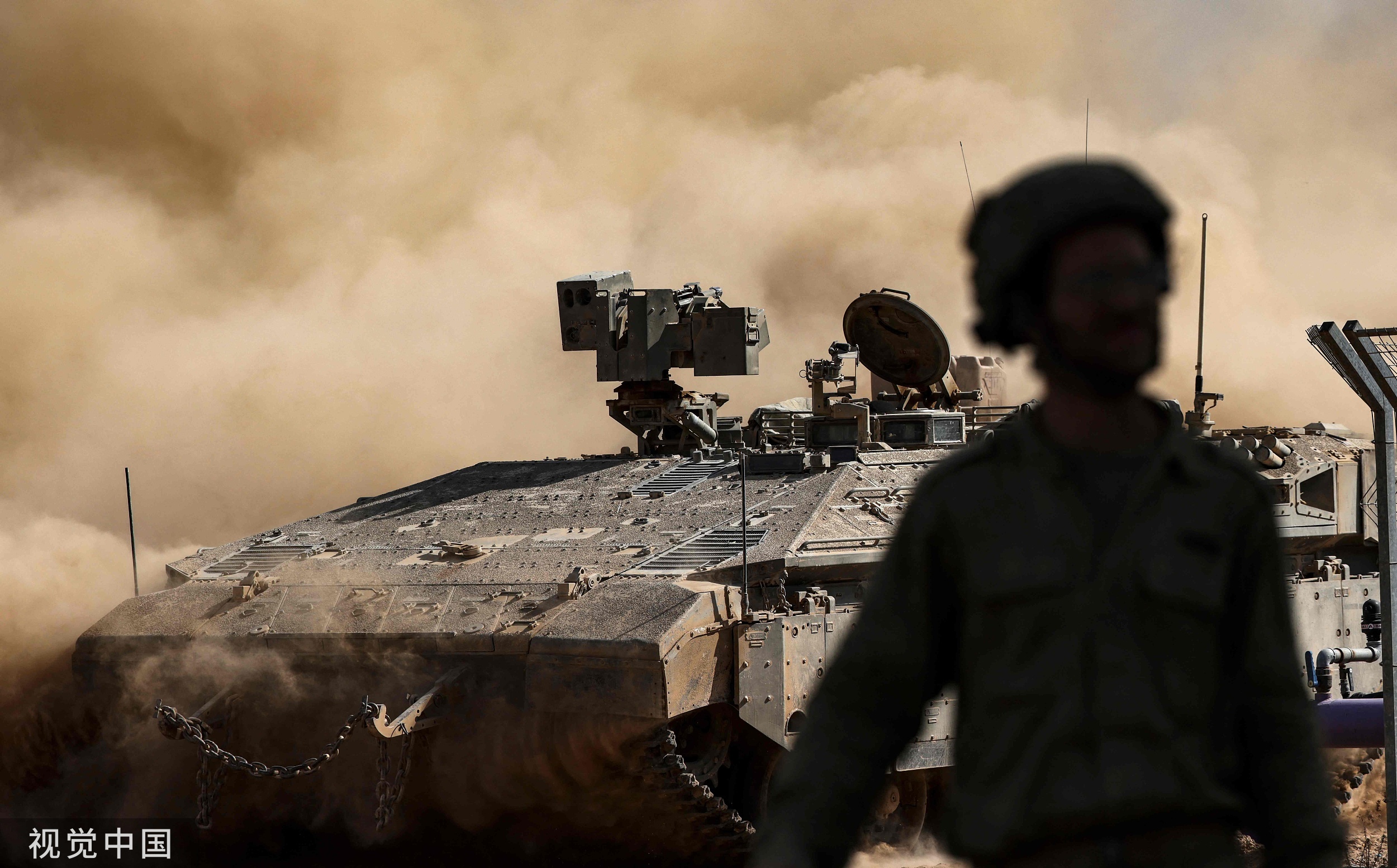 当地时间2023年10月15日，以色列加沙边境，在以色列和巴勒斯坦伊斯兰组织哈马斯的持续战斗中，一辆以色列装甲车在边境附近田野上行驶。
