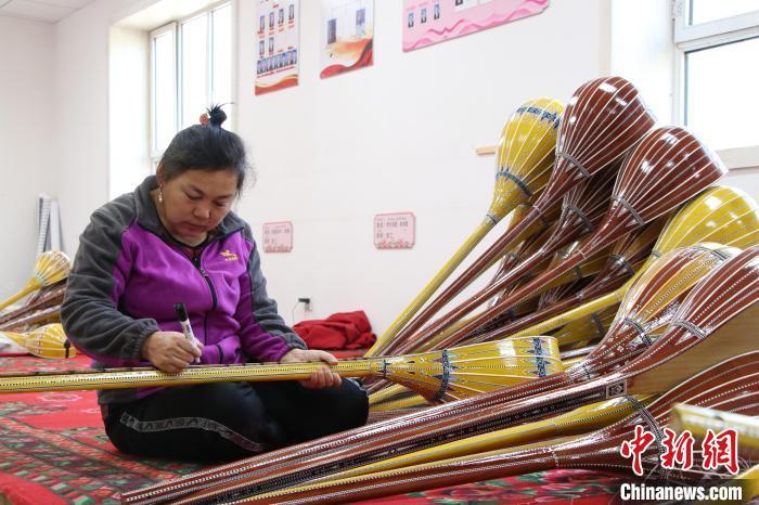 目前,新和县依其艾日克镇加依村乐器产业园内共有160余人稳定就业,图为村里的妇女在乐器产业园工作。苟继鹏 摄