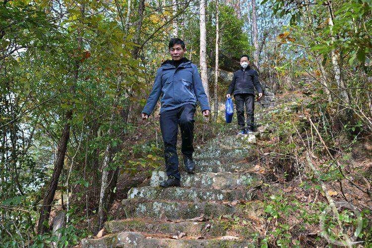 △“消麻师”刘智勇(前)、谭红军(后)为记者探访鱼背山带路