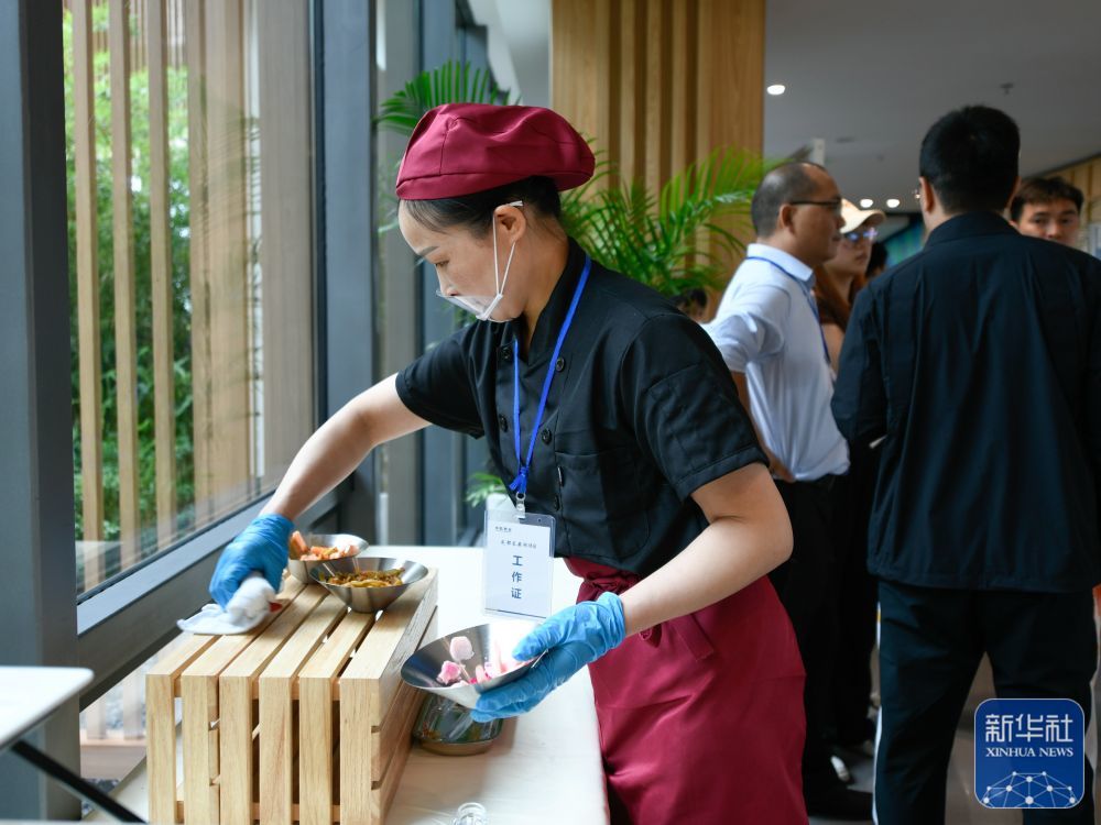 ↑7月14日,在成都大运会主媒体中心媒体餐厅,工作人员在整理食品台。新华社记者 胥冰洁 摄