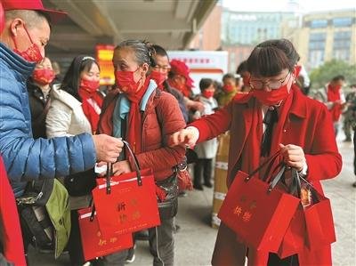 王凤(右)给回家过年的员工发礼包。 受访人供图