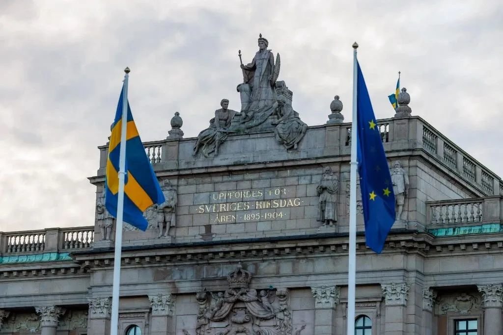 1月1日，在瑞典首都斯德哥尔摩，瑞典议会大楼外悬挂瑞典国旗和欧盟旗帜（来源：新华社）