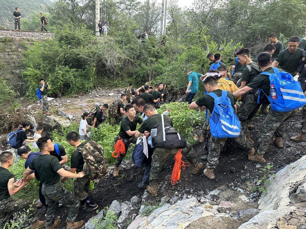 8月2日，Z180次滞留旅客在武警北京总队机动第三支队官兵的帮助下徒步前往转运客车。新华社记者 王艳刚 摄