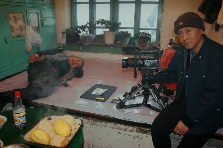 徐童(右)在唐小雁家拍摄“老唐头”(炕上)