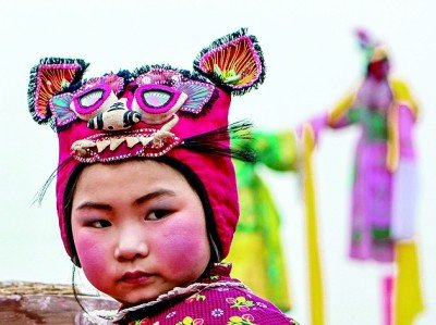 社火游演现场,戴虎头帽的孩子.冯晓伟/摄影