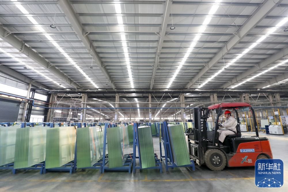 1月28日，在位于湖南资兴经济开发区的旗滨光伏光电玻璃有限公司，工人在光伏组件高透基板材料生产车间忙碌。新华社发（李科 摄）