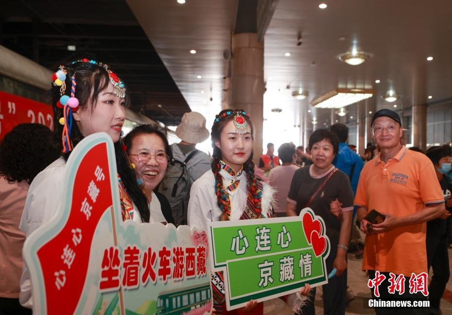 5月28日，北京援藏重点支持项目——2023年首趟“心连心&middot;京藏号”旅游列车载着400多名游客从北京西站发车。该旅游列车全程共计14天，将途经西宁、拉萨、林芝、山南等地。图为游客在站台与工作人员合影。
