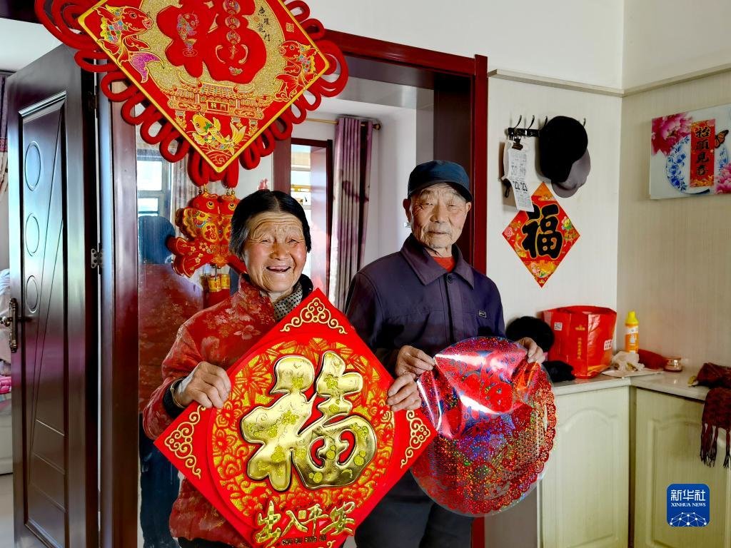 刘福有（右）和老伴在山西省忻州市岢岚县广惠园移民新区家中（2021年12月22日摄）。新华社发