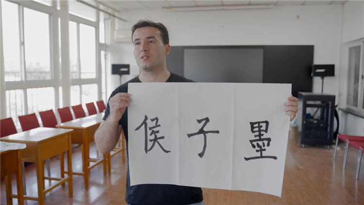 侯子墨展示自己写出的书法中文名“侯子墨”。受访者供图