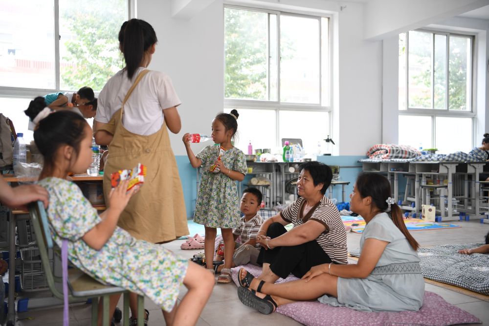↑8月3日，群众在涿州市第三中学安置点内休息。
