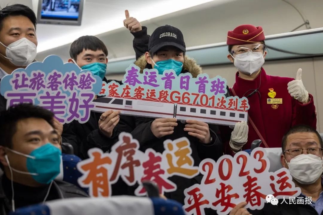 2023年1月7日,北京,2023年春运首班列车上,乘客与乘务员合影。2023年春运期间客流总量约为20.95亿人次,比去年同期增长99.5%,恢复到2019年同期的70.3%。摄影 徐讯/人民画报