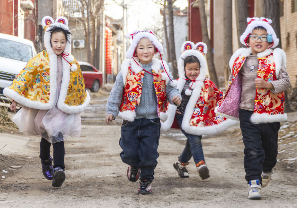 ↑1月19日，在山西省运城市盐湖区乔阳村，孩子们穿戴兔衣、兔帽饰品玩耍。新华社发（姜桦 摄）