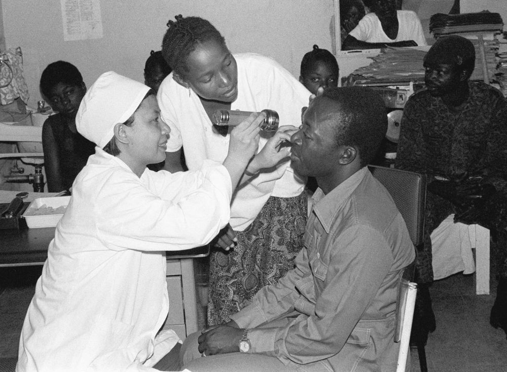 ↑1979年3月，在扎伊尔（即现在的刚果（金））首都金沙萨的金丹堡医院，中国眼科医生在为当地病人检查。新华社记者 戈春江 摄