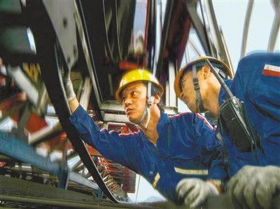 2006年，孔祥瑞（左）和同事在检修港口装卸设备。天津港集团供图