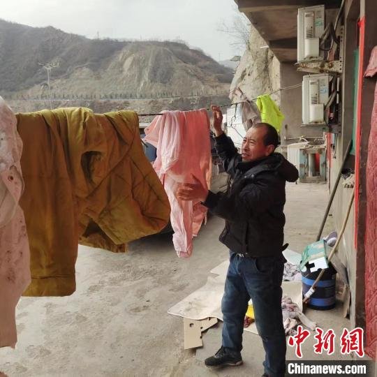 刘引强晾晒获救溺水者的衣服。 岳庄渡口 摄