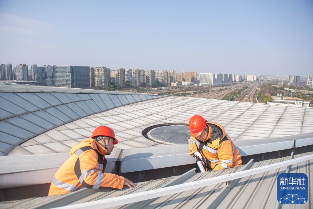 1月21日,杭州房建公寓段工人徐烜泱(右)与金一鸣在杭州东站屋面进行巡检。新华社记者 江汉 摄