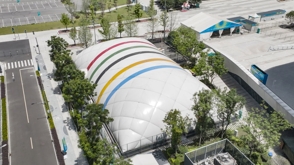 ↑这是7月22日在成都高新体育中心多功能馆外拍摄的临时训练气膜馆（无人机照片）。该临时训练气膜馆采用轻型装配式气膜结构，利用气压来支撑，无需任何梁、柱，可得到更大的完全净空的建筑空间，具有节约能源、减少水资源消耗、降低二氧化碳排放量、延长使用寿命、降低建筑物运行成本、促进可持续发展等优点。 新华社发