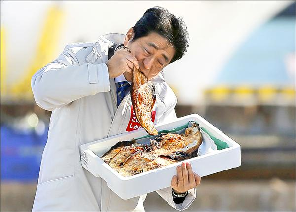 〓 前首相安倍晋三在镜头下捧着一箱福岛鱼干猛吃的画面堪称经典。