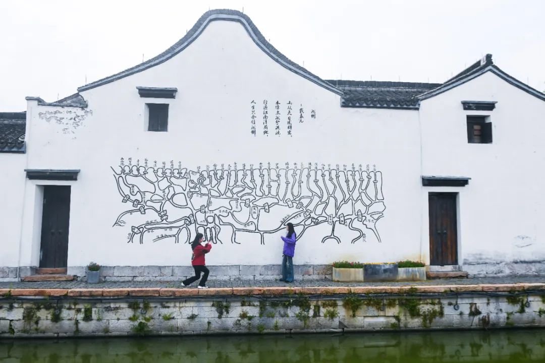 图为游客在位于太湖南岸的浙江湖州吴兴区织里镇义皋村的古村落景区