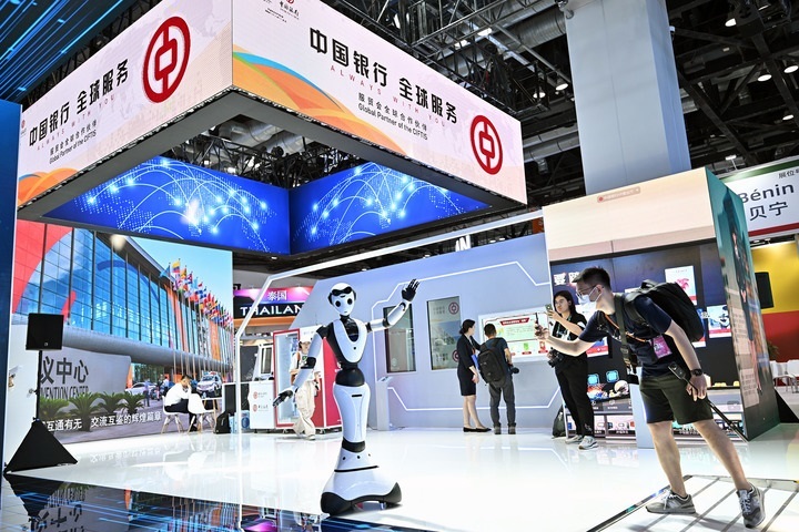 9月1日,媒体记者在国家会议中心中国银行展台拍摄一款迎宾接待机器人.
