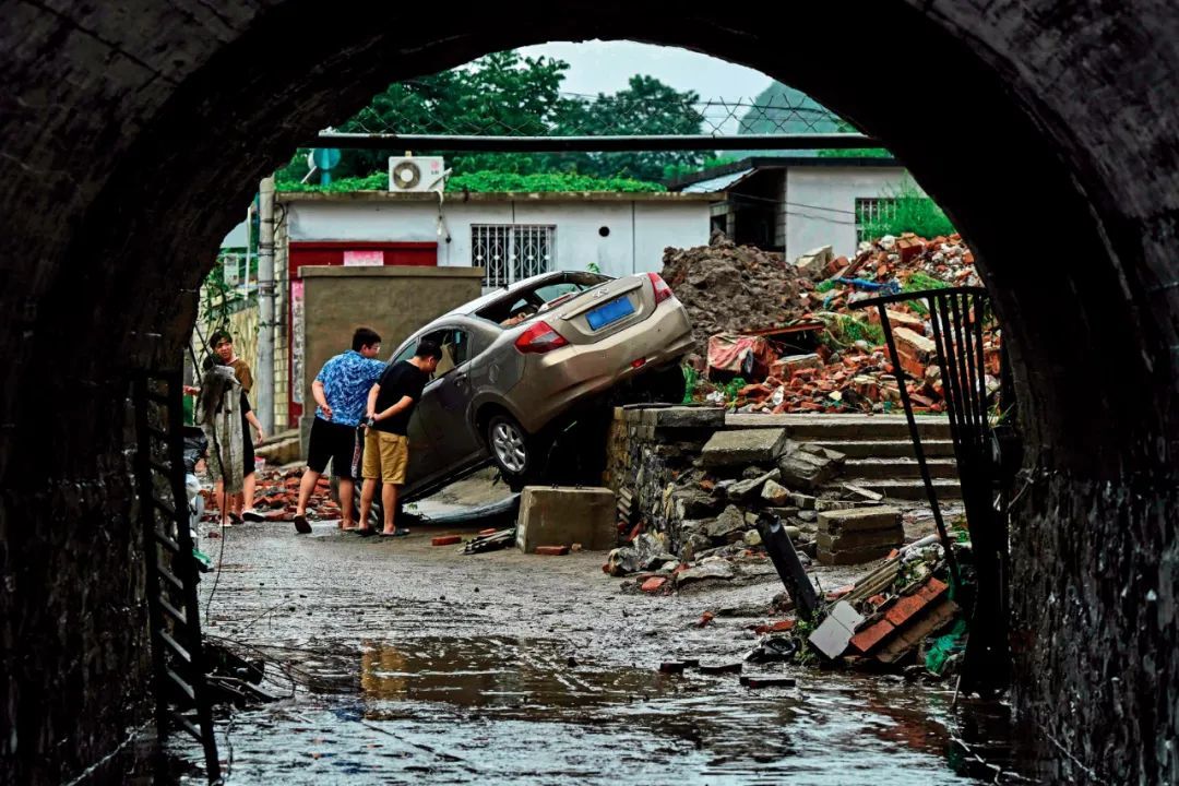 8月1日，北京市房山区，人们在暴雨过后查看受损车辆。图/视觉中国