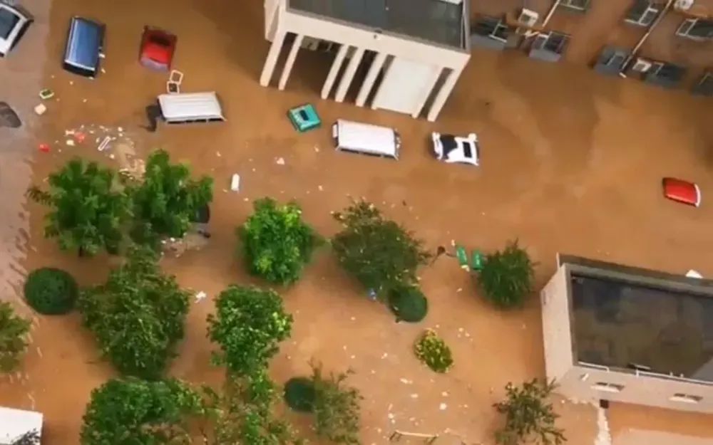 8月1日上午，金阳瑞景小区的积水已经淹到汽车车顶 / 图源：新京报