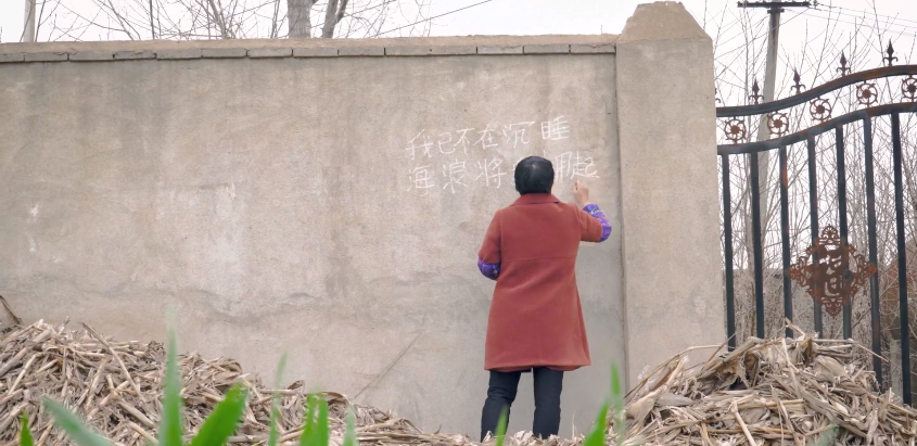 韩仕梅在写诗。/局外人《墙里写诗的农妇：用诗句为生活开一扇窗》