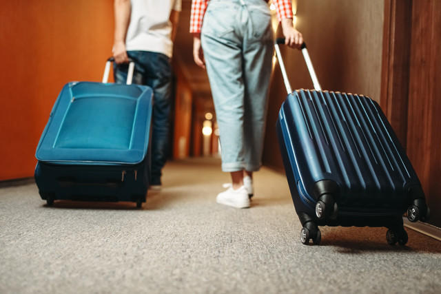 带着行李箱的情侣走过酒店走廊,Couple with suitcase walking by the hotel corridor.jpg