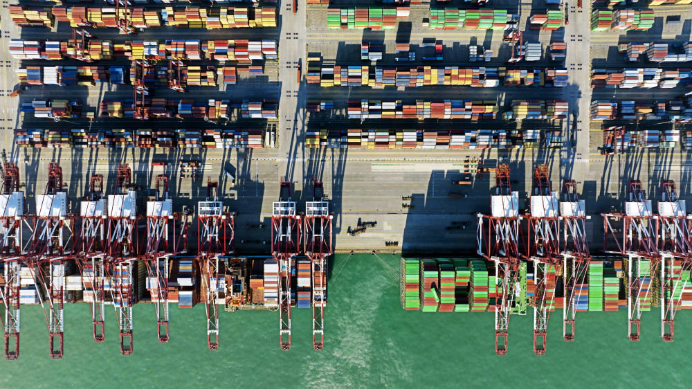 1月27日，集装箱货轮在青岛港前湾集装箱码头装卸货物（无人机照片）。新华社记者 李紫恒 摄