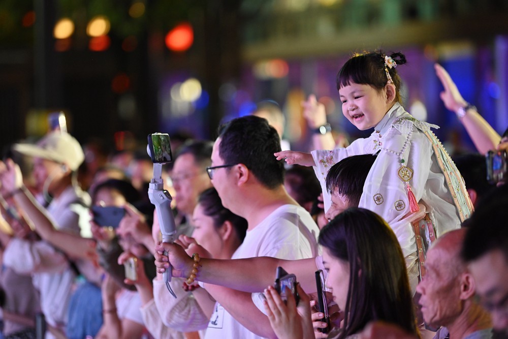 西安大唐不夜城，身着古装的小朋友骑在父亲的肩上参与互动演出 图片来源：新华社