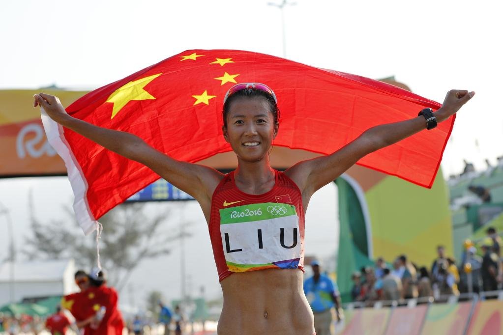 2016年8月19日，里约奥运会田径女子20公里竞走比赛，刘虹在夺冠后高举国旗庆祝。新华社记者沈伯韩摄