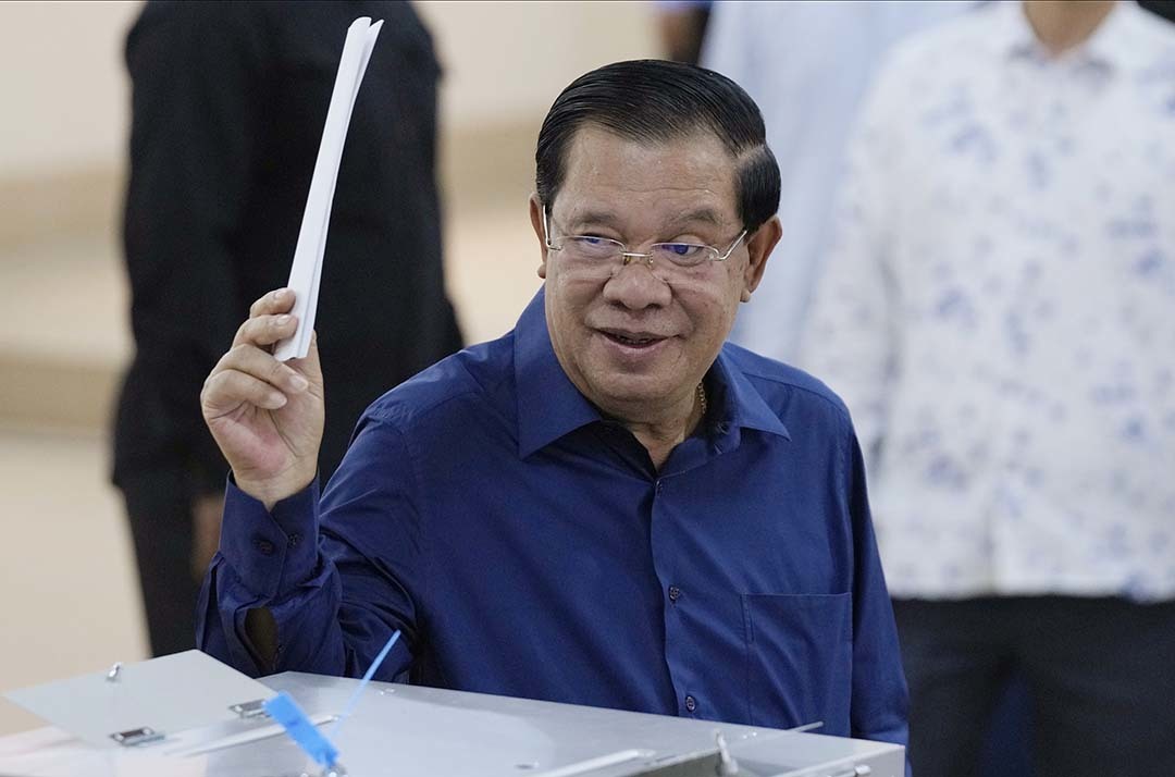 当地时间2023年7月23日，柬埔寨干丹省大金欧，柬埔寨大选期间，柬埔寨首相洪森在投票站投票前举起选票。本文图片均为 视觉中国 图