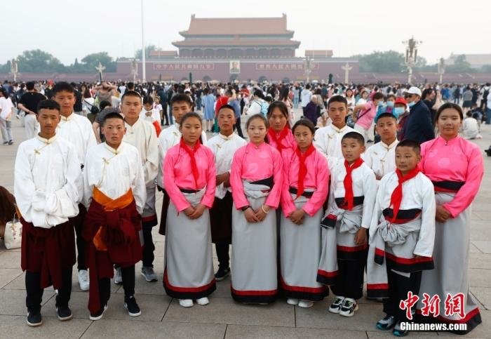 6月1日，来自青海省玉树藏族自治州儿童福利院的部分藏族青少年在天安门广场观看升旗仪式。图为升旗仪式后孩子们在天安门广场合影。 中新社记者 富田 摄