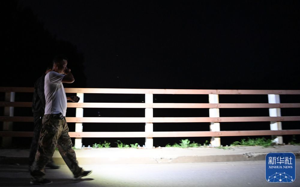 郝庆水（前）和村干部准备一起去巡视河堤（8月3日摄）。