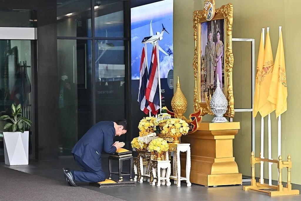 8月22日，泰国前总理他信在曼谷廊曼机场向国王的画像鞠躬致敬。图/视觉中国