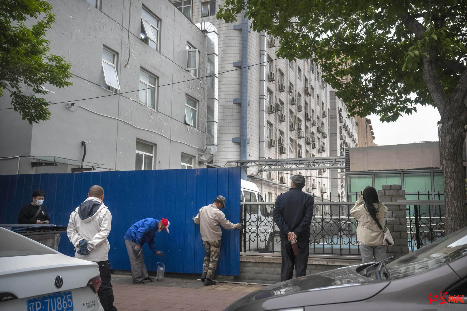 2023年4月20日，工人在北京长峰医院周围设置金属路障。Onlookers watch as workers erect metal barricades around the Beijing Changfeng Hospital in Beijing, Thursday, April 20, 2023. The death toll from a fire at a Beijing hospital rose to more than t.jpg