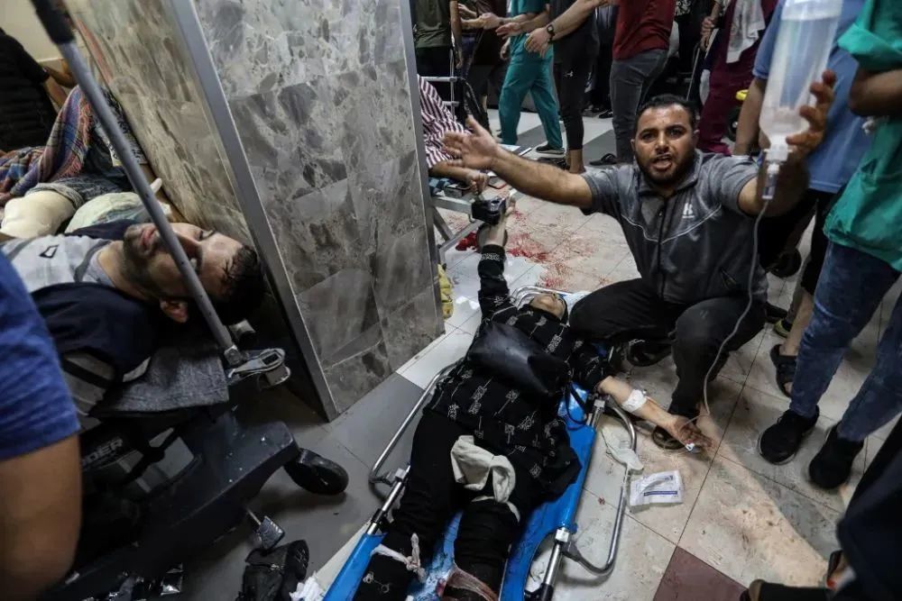 11月3日，在加沙城希法医院门口，伤者等待救治。新华社发