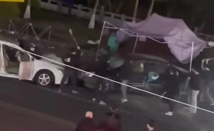 ▲多名男子打砸一辆汽车。(视频截图)