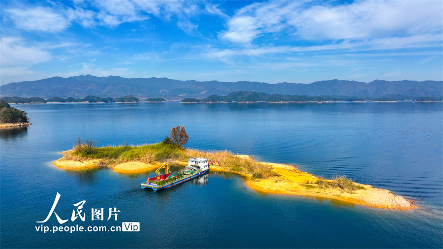 2023年12月8日，从浙江省杭州市淳安县界首乡空中俯瞰千岛湖，湖面上小岛星罗棋布、港湾纵横交错，蓝天白云与湖水交相辉映，初冬的千岛湖风景美如画。余剑锋摄（人民图片网）