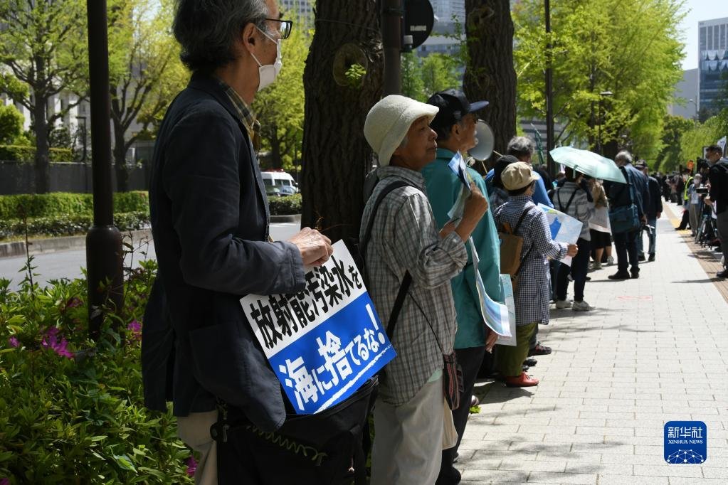 4月13日，在日本东京，民众手举标语在日本国会众议院第二议员会馆前参加集会抗议。新华社记者 岳晨星 摄